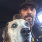 Mark and His Beagle Dog Benson in the truck. Benson is looking right into the camera.