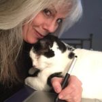 The Illustrator of Purple Cat Press Debra Toutloff. She is holding the real cat of the Bad Kitten Story. The cat is Black and White.