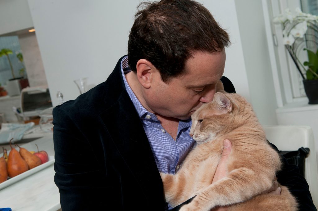 Dr. Jeff the NYC HouseCall Vet giving an orange cuddly cat hugs